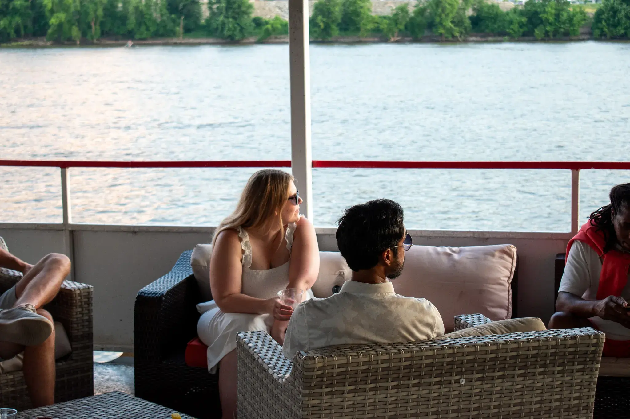 A tour group relaxing on the open-air top deck lounge with river views