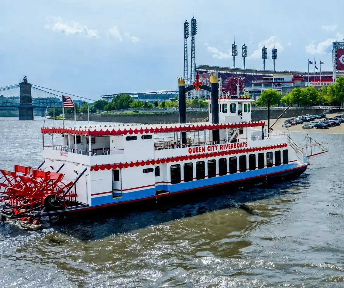 The Spirit of Cincinnati paddlewheeler cruising the Ohio River past Great American Ball Park, her red paddlewheel churning